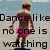 Pixelated image of a person in pink attire dancing with text overlay reading 'Dance like no one is watching' against a light background.