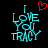 Two side-by-side pixelated text displays on black background, both reading "I LOVE YOU TRACY" in cyan block letters with a red heart above the left display.
