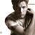 Pixelated grayscale image of a person with dark hair wearing a jacket, holding an object near their mouth against a white background.