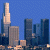 Pixelated cityscape with tall buildings under blue sky, adjacent to green background with bright green text reading Original Icons .com.
