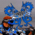 Pixelated blue dragon with orange accents on gray background, adjacent to blue with white text reading Dynasty world champs