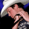 A mirrored sequence of a person in a white cowboy hat receiving a haircut, with hands holding a black hair clipper near the neck against a blue background.