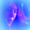 A blurry static icon with a blue and purple color scheme showing an indistinct figure's face in profile view.