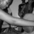Black-and-white pixelated image showing a partial figure with dark hair and clothing against a light background, featuring horizontal bands of varying grayscale tones.