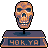 Pixelated skull head on a stand with '40K.YA' text below, orange-brown tones against gray background.