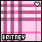 Pixelated pink and gray plaid background with a heart symbol in the top-right corner, displaying 'BRITNEY' text at bottom.