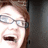 Pixelated image of a person with light brown hair and glasses, mouth open in laughter, next to pixelated text reading 'I'ma eat choo' on black background.