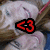 A pixelated image of a person with closed eyes and light-colored hair, overlaid with colored text elements.