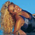 Pixelated image of a person with long blonde hair lying on a dark surface against a blue background.