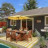 Pixelated static image of a house with yellow trim, dark windows, and brown siding under blue sky.