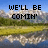 Pixelated landscape with mountains, grassy fields, and water reflections under a blue sky, overlaid with black text reading "WE'LL BE COMIN' ROUND THE MOUNTAIN" across four