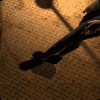 Animated sequence of a person in camouflage clothing performing crouching and stretching movements on a textured brown surface.