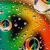 A colorful, pixelated animation of a cartoon character with large eyes and vibrant green-yellow-orange background patterns.