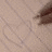 A static image with a light brown background and faint diagonal lines, featuring a dark brown rectangular shape in the upper right corner.