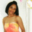 A pixelated static image shows a person with short dark hair wearing a strapless dress with yellow and orange gradient colors against a light background.