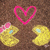 A static pixel art image shows two yellow cartoon characters with pink bows and blue eyes, a pink heart outline above them, and a brown pixelated background.