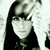 Pixelated grayscale portrait of a person with long dark hair and bangs, wearing a dark top against a light background.