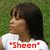A pixelated image of a person with dark hair wearing a white shirt, standing against a green background with red text reading 'Sheen' below.