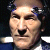 Pixelated static image of a human face with visible facial features and partial clothing, rendered in low-resolution style typical of early 2000s digital art.