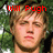A pixelated image of a person with light brown hair against a green foliage background, featuring red text above the head.