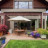 Static pixelated image of a house with a porch, green lawn, and colorful flowers in front.