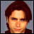 Pixelated image of a person with reddish-brown hair against gray background, next to text reading 'I ❤️ John Stamos' on matching gray backdrop.