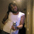 A pixelated image shows a person holding a camera, wearing a light-colored shirt and dark pants against a blurred background.
