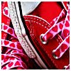 Red and pink patterned fabric with white stitching and a silver zipper, showing a close-up of a garment's interior.