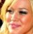 Pixelated close-up of a person's face with light-colored hair, visible eyes, nose, mouth, and skin tones in warm yellow-orange hues.