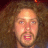 A pixelated image of a person with curly brown hair and a mustache, with yellow text reading 'fuck' and 'mustard' in different sections.