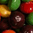 Pixelated image of assorted colorful candies with a pink text overlay reading 'Taste the RAINBOW' in green letters.
