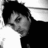 Black-and-white pixelated image with a person in the top-left corner and pixelated text on a black background.