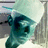 Pixelated image of a teal-colored character with a white hat, partially visible text reading 'ShnIka' and 'Please' on black backgrounds.