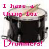 A black drum with a white drumhead and a single drumstick resting on top, overlaid with pink text reading "I have a thing for Drummers!".