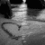 Black-and-white image with a heart-shaped mark on fabric, overlaid text reading "We've all been lost for most of this life".