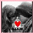Static pixel art of a dark, abstract figure with a red heart symbol over its chest and partial text below.