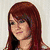 A static image of a woman with long red hair, wearing a white top against a light background.