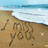 Beach scene with 'I love you' written in sand and a red heart containing the text 'BEN'.