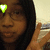 A person with dark hair and glasses makes a peace sign, with four heart icons changing color in the corners.