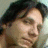 A pixelated close-up of a person's face with dark hair, showing two side-by-side views where the right view has additional text overlay.