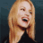 Static pixelated image of a person with long blonde hair wearing a dark top against a dark blue background, rendered in low-resolution style typical of early 2000s digital art.