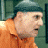 A 48x48 pixel animated buddy icon featuring a split composition with a person in an orange jumpsuit on the left and a red mailbox with "ARRESTED BY MILITARY" text on the right, displayed as two sampled frames from an animation.