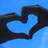 Two hands form a heart shape against a blue background, with pixelated text on adjacent