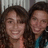Two people with dark curly hair smiling closely together in a static pixelated image.