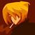 A pixelated avatar with a rounded shape, featuring a gradient of yellow and orange tones against a dark brown background.