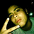 Pixelated image of a person with light brown hair resting their head on one hand, wearing a green garment against a black background.
