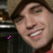 Animated contact sheet of a person wearing a brown beanie and red shirt with pink pixelated symbols changing across frames against a dark background.