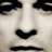 Static pixelated close-up of a face with dark eyes, nose, and mouth against light skin tones.
