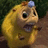 Pixelated cartoon character with yellow fur, large black eyes, and a blue gem on its head holding an object near its mouth.
