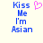 Blue pixelated text reads 'Kiss Me I'm Asian' with a pink heart symbol above the word 'Me', displayed on a light background.